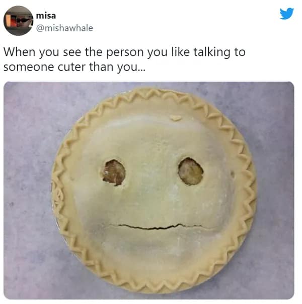 A self-deprecating awkward meme showing a raw pie crust with two poked holes and a slit that looks like a very sad, deflated face. The text reads: "When you see the person you like talking to someone cuter than you..."