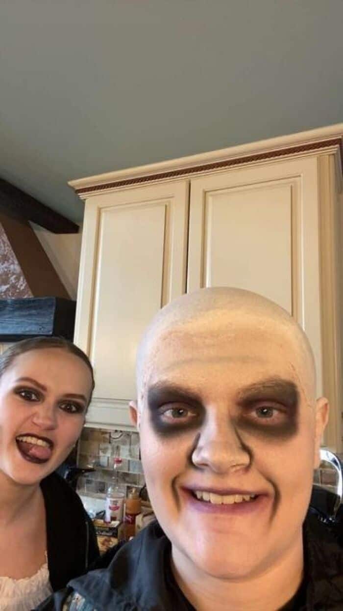Two performers in Halloween-style stage makeup including zombie eye shadow and white face paint for school production