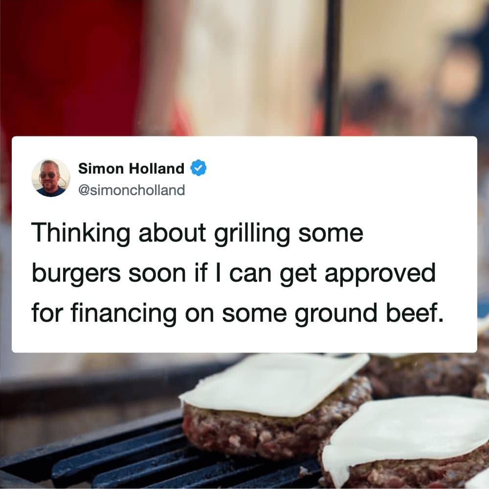 A timely grilling meme addressing the high cost of living. Over a close-up shot of cheeseburgers melting on the grill, user Simon Holland jokes about needing to get a high-interest loan approved just to afford a few pounds of ground beef.