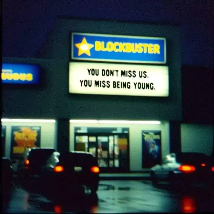 Blockbuster store marquee at night reading you don't miss us you miss being young