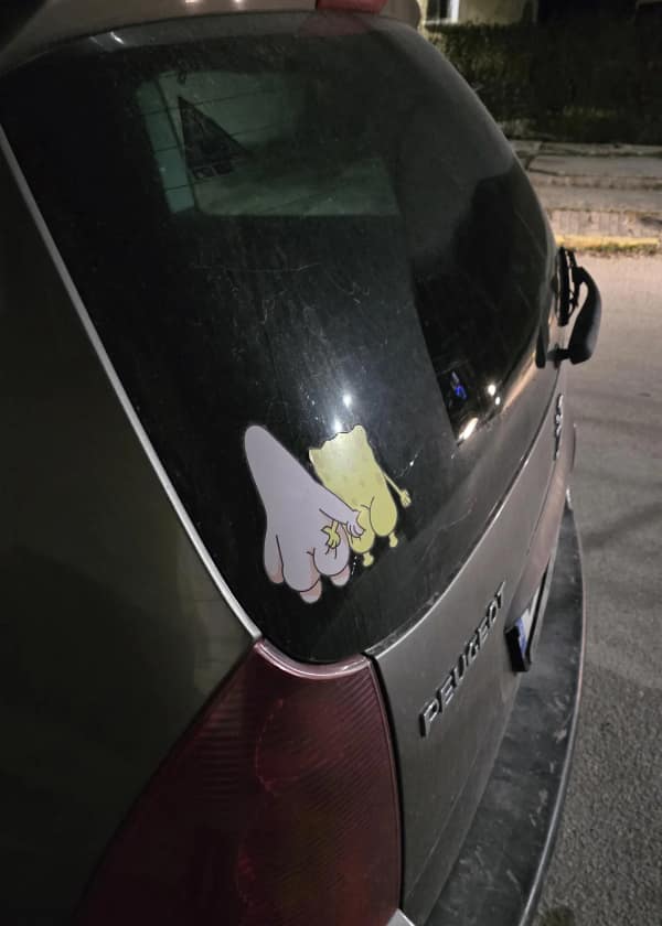 A disturbing blursed image of two decals on the rear window of a Peugeot. The stickers depict Spongebob Squarepants and Patrick Star from behind, both completely naked, with Patrick suggestively resting his hand on Spongebob's yellow backside.