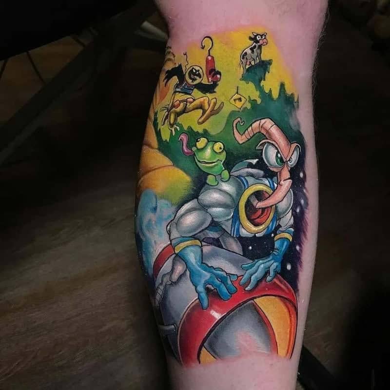 Earthworm Jim and companion characters vibrant cartoon tattoo on lower leg with rocket scene