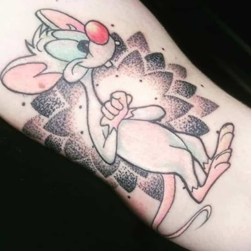Pinky from Pinky and the Brain cartoon tattoo with dotwork geometric background on forearm
