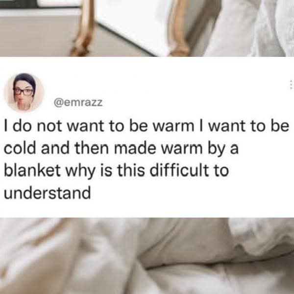A relatable classic meme tweet by @emrazz that explains the science of "cozy." It states: "I do not want to be warm I want to be cold and then made warm by a blanket why is this difficult to understand," over a background of rumpled white bedsheets.