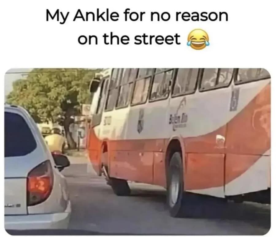 A physical comedy classic meme showing a bus on a city street with its rear wheel buckled inward at a severe 45-degree angle. The caption reads, "My Ankle for no reason on the street," personifying the mechanical failure.