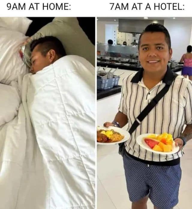A relatable classic meme comparing two sleep schedules. On the left, "9AM AT HOME" shows someone buried under covers; on the right, "7AM AT A HOTEL" shows the same person beaming with two full plates of breakfast buffet food.