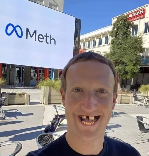 satirical classic meme featuring a photoshopped selfie of Mark Zuckerberg. He appears with missing and decayed teeth in front of a corporate building where the "Meta" logo has been edited to read "Meth."