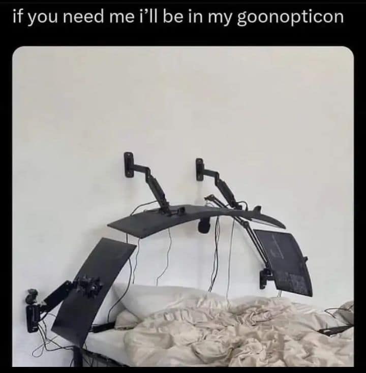 A chaotic and terminally online classic meme showing a bed with several high-end computer monitors mounted on articulated wall arms, hovering directly over the pillows. The caption reads: "if you need me i’ll be in my goonopticon."