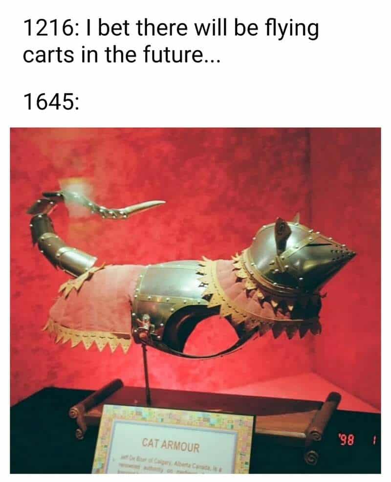 A photo of an actual museum display featuring a full set of polished steel cat armor from the 17th century. This classical art meme mocks historical expectations of the future, showing that while people in 1216 dreamed of flying carts, people in 1645 were busy making plate mail for felines.