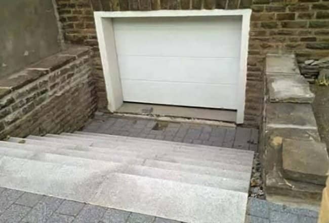 Garage door installed at bottom of descending staircase making vehicle access completely impossible