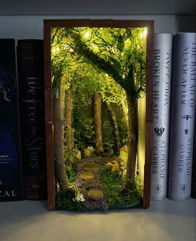 Enchanted forest cool bookends featuring a winding stone path, mossy trees, and warm miniature fairy lights nestled between fantasy novels.