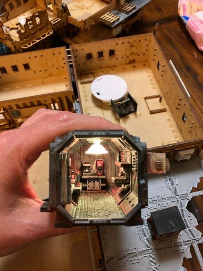 Miniature sci-fi spaceship kitchen cool bookends featuring an octagonal corridor with industrial flooring, a tiny coffee station, and a glowing overhead lamp.