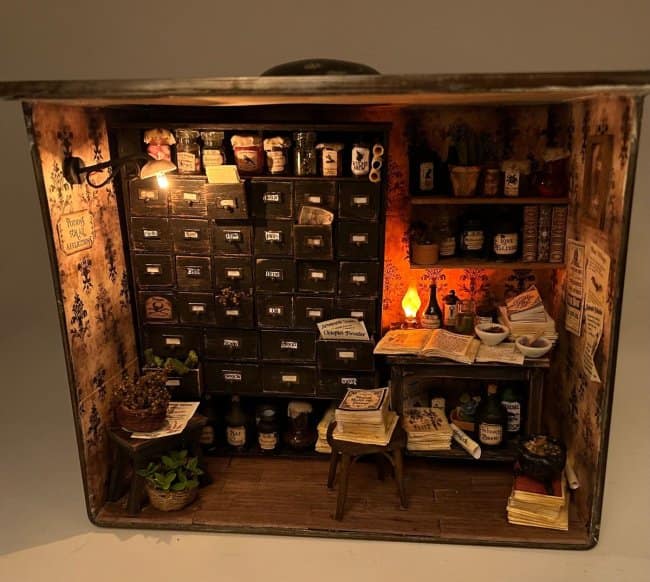 Mystical apothecary shop cool bookends showing a miniature alchemy lab with a wall-sized wooden chest of drawers, herb baskets, and flickering lanterns.