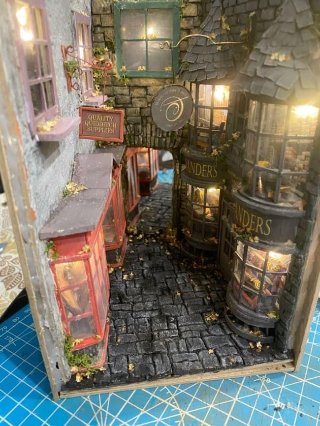 Wizarding world cool bookends modeled after Diagon Alley with shop signs for Ollivanders and Quidditch supplies under warm, magical lighting.