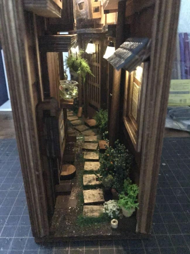 Zen garden cool bookends showcasing a miniature stepping stone path surrounded by lush greenery and tiny, realistic potted plants.