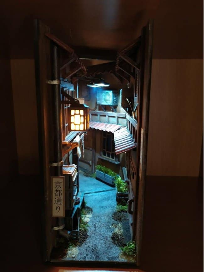 Traditional Japanese alley cool bookends with glowing lanterns, dark wood architecture, and a vertical sign written in Japanese characters.