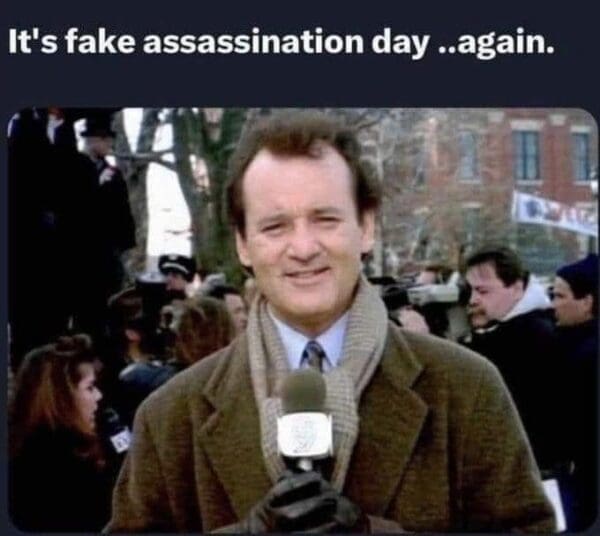 correspondents dinner meme featuring a weary Bill Murray as news reporter Phil Connors from Groundhog Day. The text overlay at the top reads: "It's fake assassination day ..again," capturing the cynical exhaustion of the 2026 news cycle.