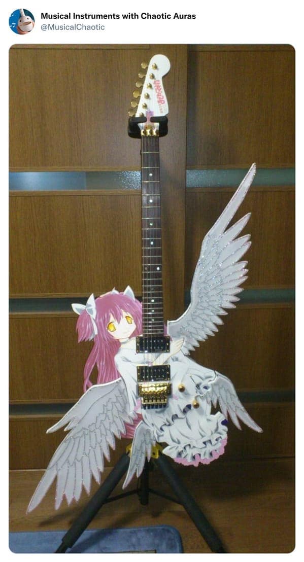 A maximalist cursed instrument anime guitar themed after Madoka Kaname. The body is an enormous, sprawling white dress with pink accents and massive feathered wings that extend far beyond the fretboard. It is a masterpiece of "magical girl" excess that looks impossible to hold comfortably.