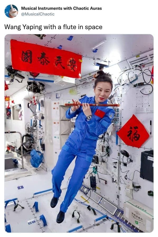 A surreal and slightly cursed instrument moment captured on the Tiangong space station. Chinese astronaut Wang Yaping is shown floating in zero gravity while playing a traditional wooden flute. The tech-heavy interior is draped in festive red banners, blending ancient music with interstellar travel.
