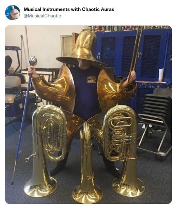 A peak cursed instrument photo of a student wearing "Tuba Armor." The person is encased in brass, with tuba bells serving as pauldrons and a pointed bell used as a wizard’s hat. They hold a conductor’s baton like a magical staff, ready for a high-decibel quest.