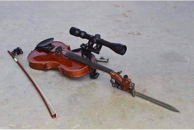 A tactical cursed instrument consisting of a classic wooden violin modified for warfare. It has a long-range sniper scope mounted above the bridge and a sharp metal bayonet fixed to the scroll, turning a delicate orchestral tool into a literal weapon of "sharp" notes.