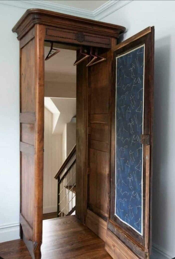 A literal "closet to Narnia" design fail featuring an antique wooden wardrobe that, when opened, serves as the main entrance to a full staircase leading to a lower level of the house.