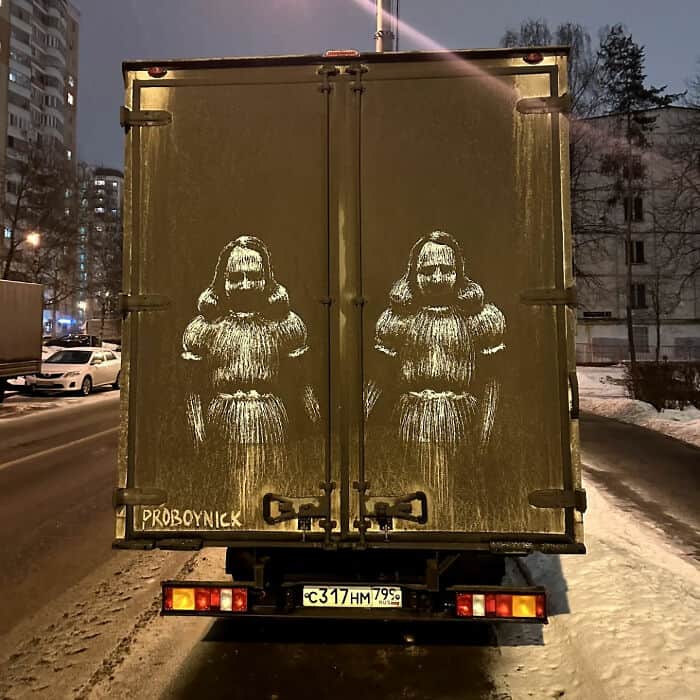 The creepy twins from The Shining drawn into road grime on truck cargo doors.