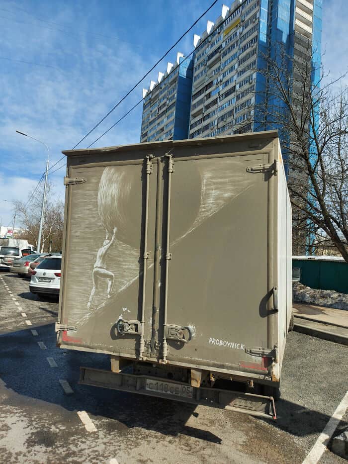 Sisyphus pushing a giant boulder etched into the grime on a dirty white truck.