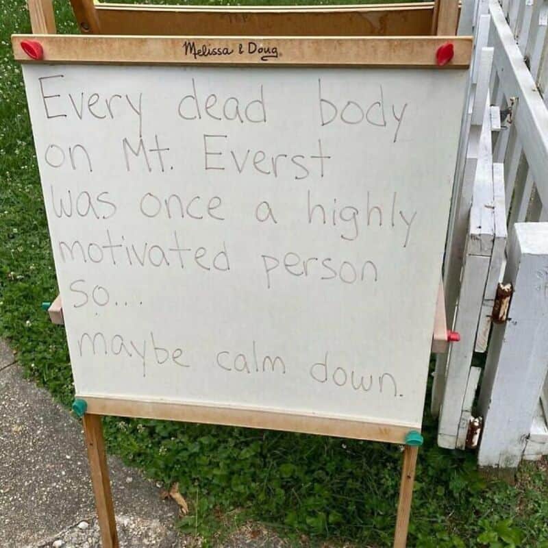 Whiteboard sign outside reads every Mt Everest dead body was motivated so maybe calm down