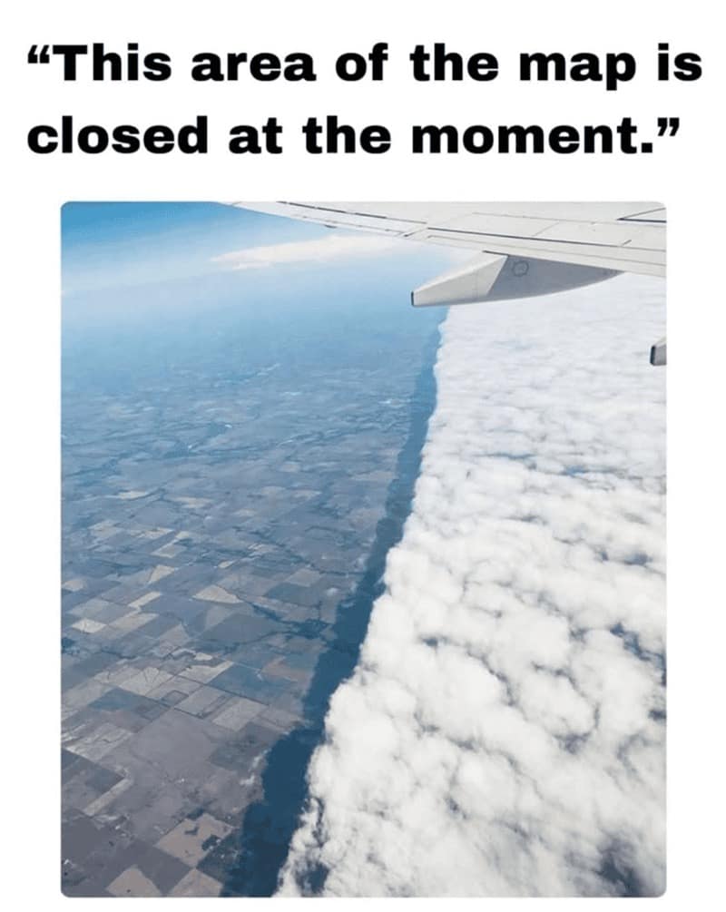 funny rpg meme showing an aerial view from an airplane where a perfectly straight, vertical wall of dense white clouds meets clear land. The text overlay reads: "This area of the map is closed at the moment," referencing invisible walls and regional locks.