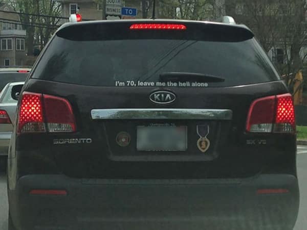 A blue SUV featuring a popular [funny bumper sticker] satirizing stick figure families on the rear liftgate. It displays a graphic of a T-Rex dinosaur leaning over to eat several stick figures, accompanied by the white text: "YOUR STICK FIGURE FAMILY WAS DELICIOUS."