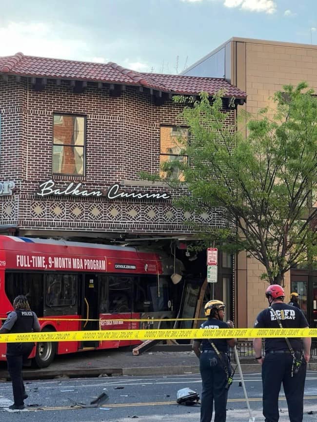 Red public transit bus crashed through front wall of Balkan Cuisine restaurant with firefighters on scene