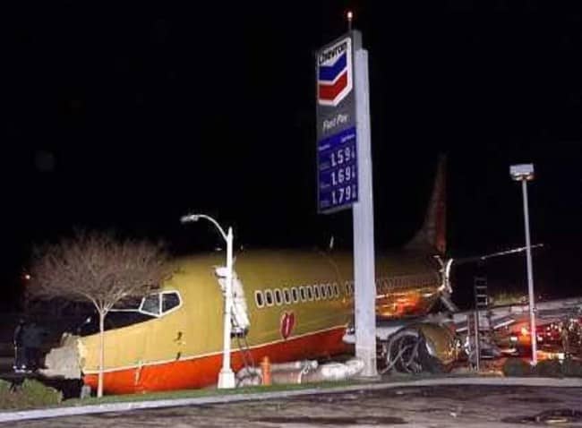 Southwest Airlines Boeing 737 aircraft resting at Chevron gas station after runway overrun at night