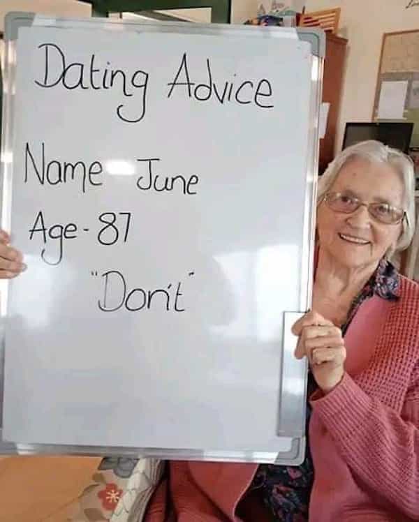 An 87-year-old woman named June holding a whiteboard that simply says "Don't" for dating advice.