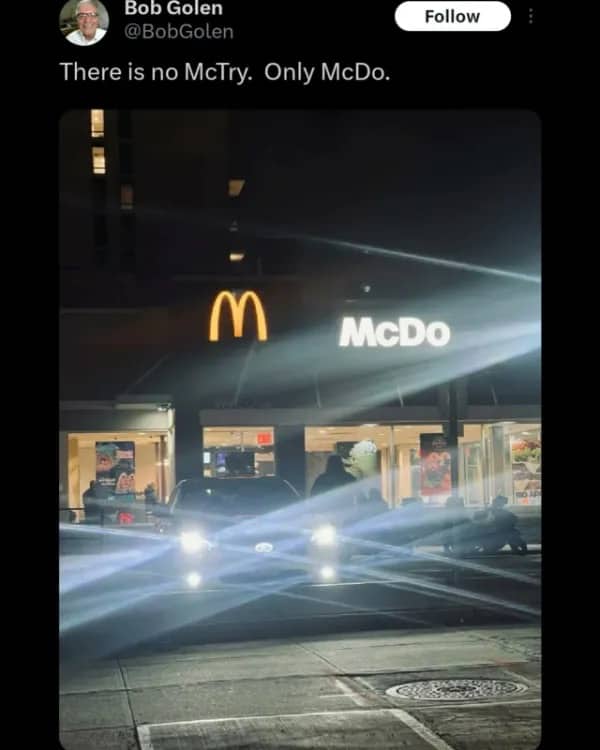 A McDonald's restaurant at night with a broken sign that hilariously reads McDo instead of the full name.