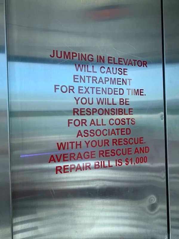 A stern but funny osha violation picture of a sign inside an elevator warning that jumping will cause "entrapment for extended time" and result in a $1,000 rescue bill.