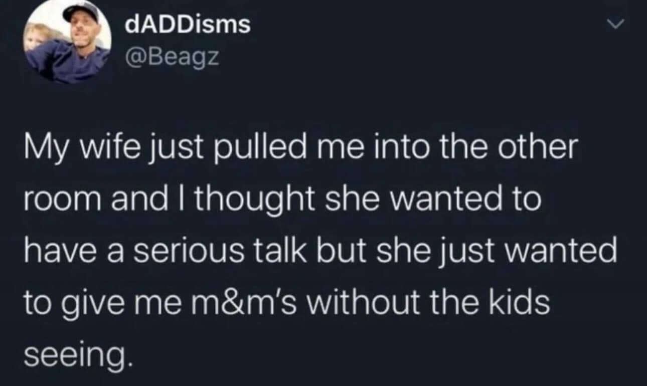 Funny tweet about a wife secretly giving her husband M&Ms away from their children's sight.