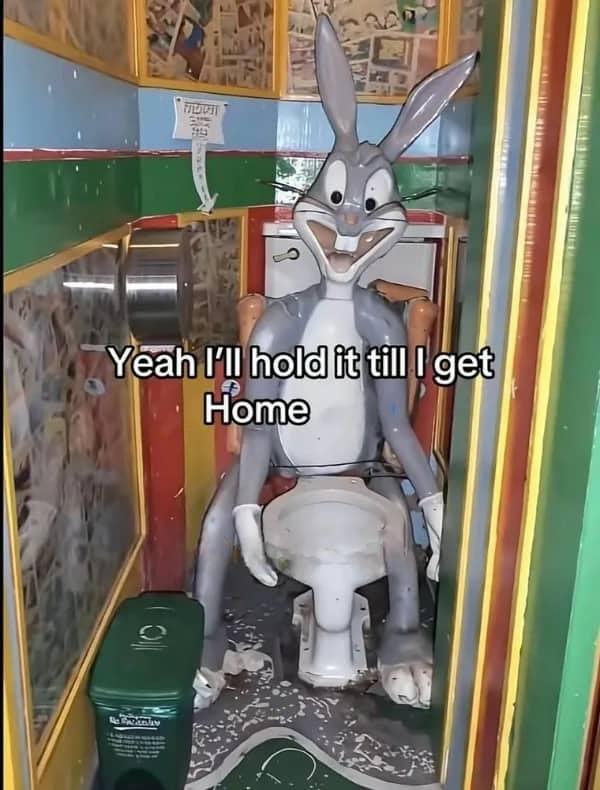 Creepy Bugs Bunny statue sitting on a toilet with text saying I will hold it.