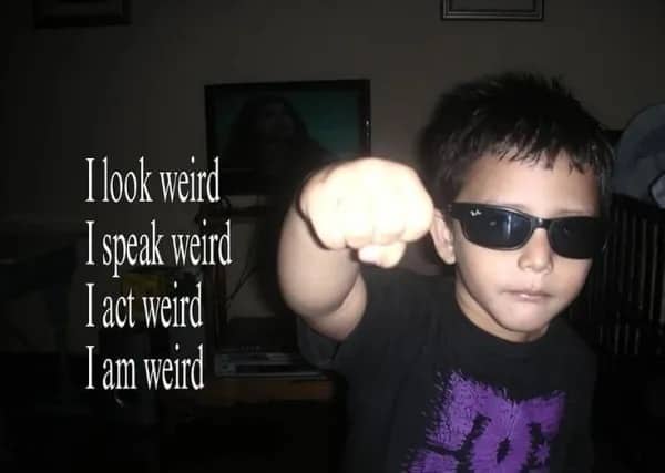 Edgy young boy wearing sunglasses with text describing himself as weird while doing a fist-bump.