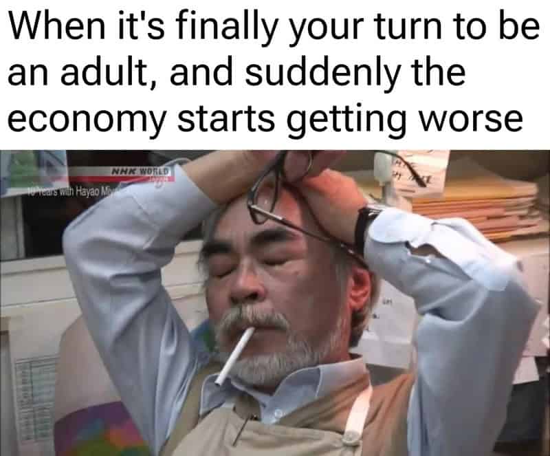 A funny relatable meme featuring a legendary photo of animator Hayao Miyazaki looking utterly defeated, head in his hands while smoking a cigarette. The text captures the specific pain of finally reaching adulthood only to have the global economy immediately collapse.