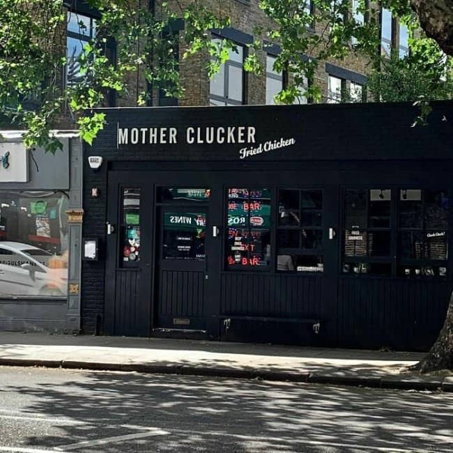 Mother Clucker fried chicken restaurant exterior with sleek black storefront, cheeky chicken-themed pun.