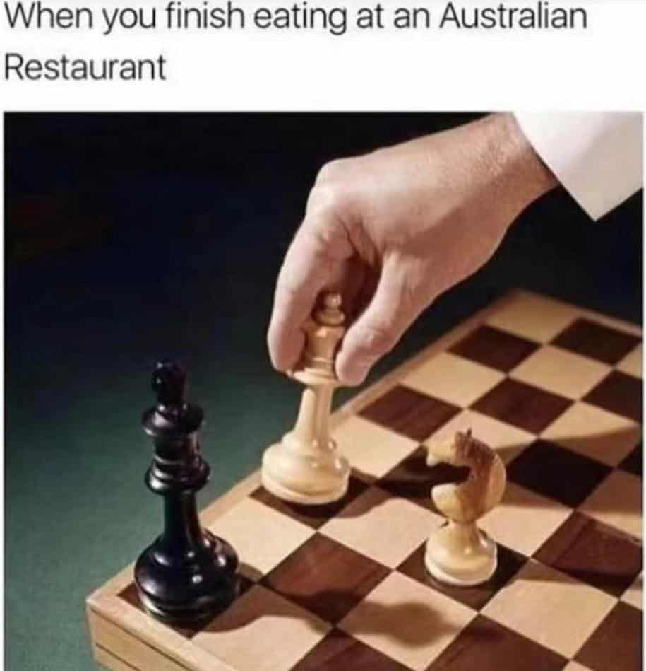 Chess king piece being tipped over in checkmate captioned as finishing a meal at an Australian restaurant check mate