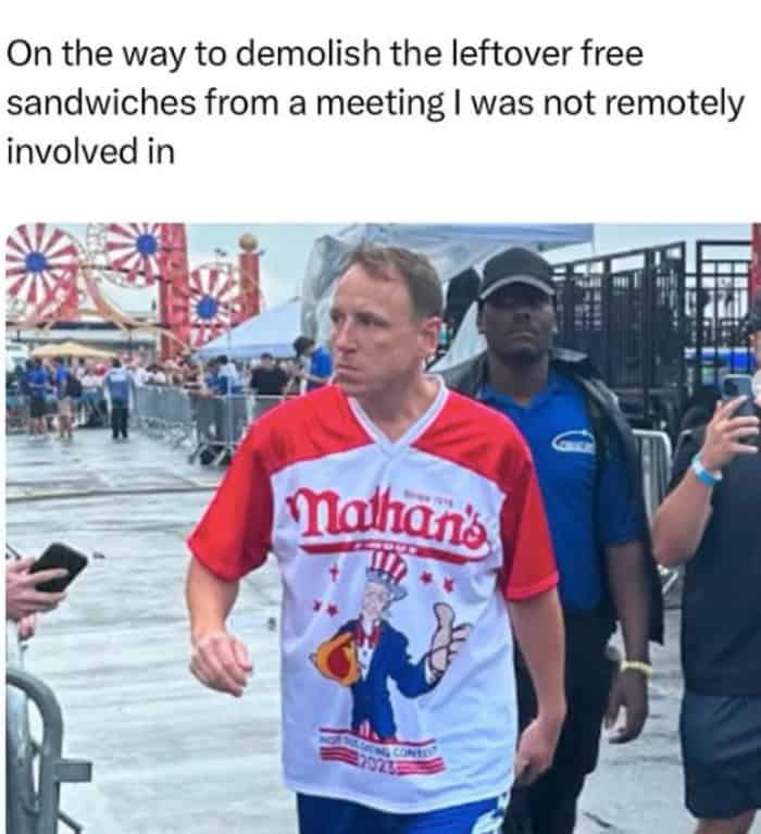 funny work meme featuring competitive eater Joey Chestnut walking with intense determination. The text reads: "On the way to demolish the leftover free sandwiches from a meeting I was not remotely involved in."