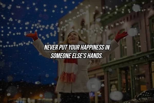 Woman joyfully raising arms in snow with hard life lesson quote about owning your own happiness