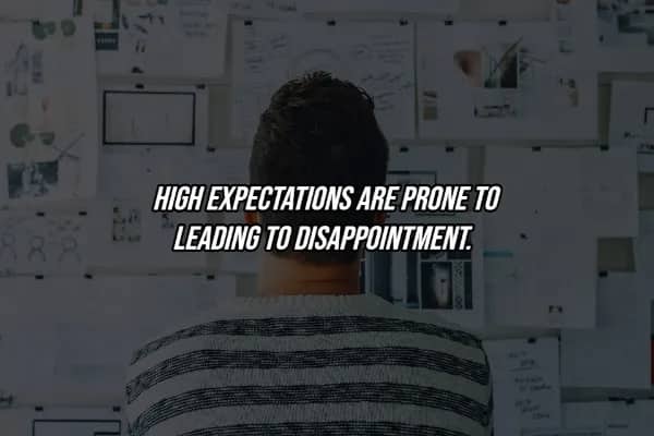 Person facing cluttered idea board with hard life lesson quote warning that high expectations lead to disappointment