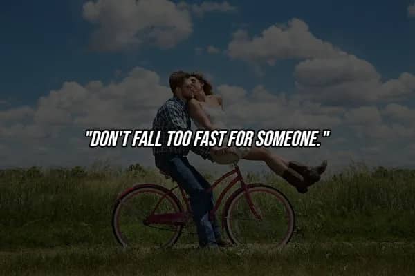 Couple on bicycle in field with hard life lesson quote cautioning against falling too fast for someone