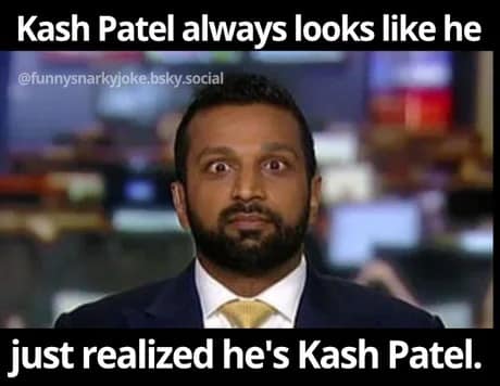 A high-octane Kash Patel meme capturing a broadcast still of Patel looking directly into the camera with an expression of pure shock. The text reads: "Kash Patel always looks like he just realized he’s Kash Patel."