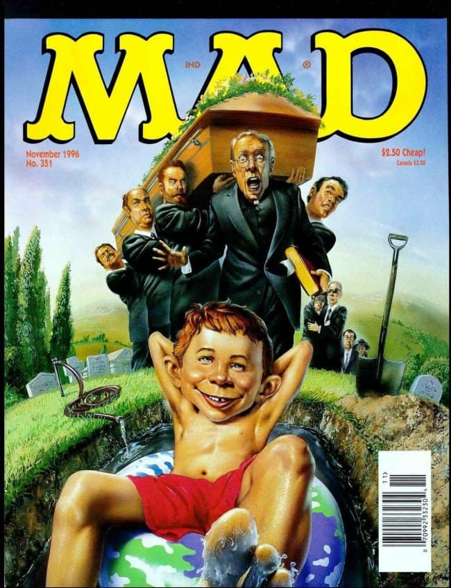 A dark and satirical vintage mad magazine cover from November 1996. Alfred E. Neuman relaxes in a red swimsuit inside an open grave that contains a globe, while a frantic funeral procession led by a terrified priest carries a coffin directly toward him in the background.