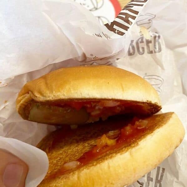 McDonald's burger fail with tiny burnt patty lost inside oversized bun with ketchup and pickles