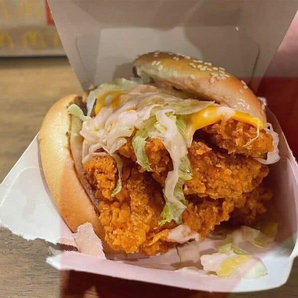 McDonald's spicy chicken sandwich fail with bun pushed sideways and ingredients falling out